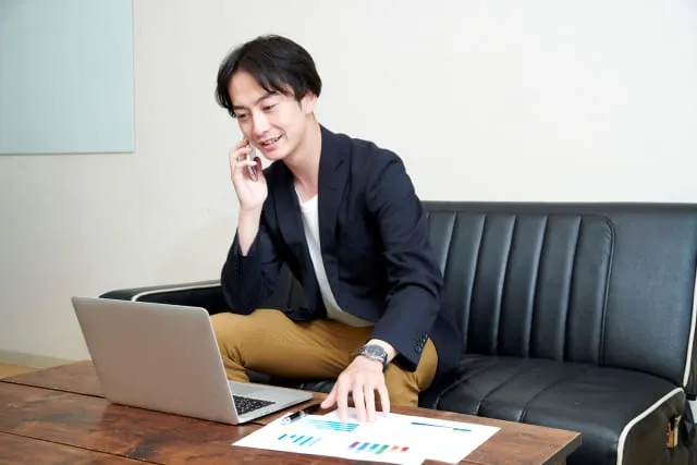 情報を見ながら不用品回収業者に電話で依頼している画像